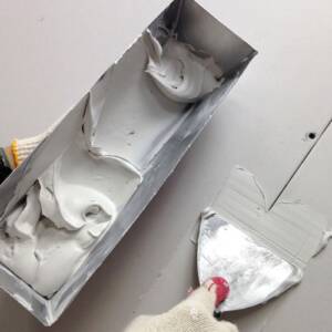 Drywall being smoothed out with a special tool